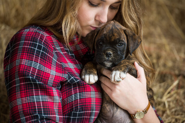 lady snuggling a puppy