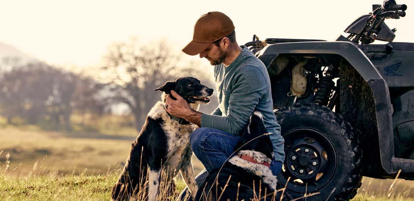 man and dog by atv