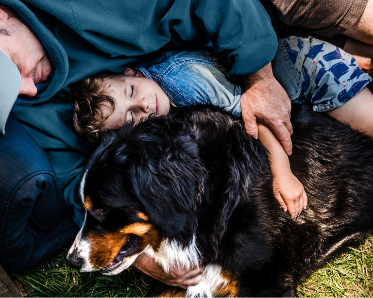 man and boy hugging dog